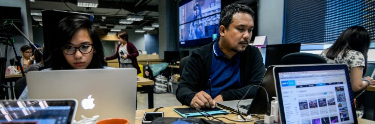 Rappler office, two people - woman and man - work at the computers