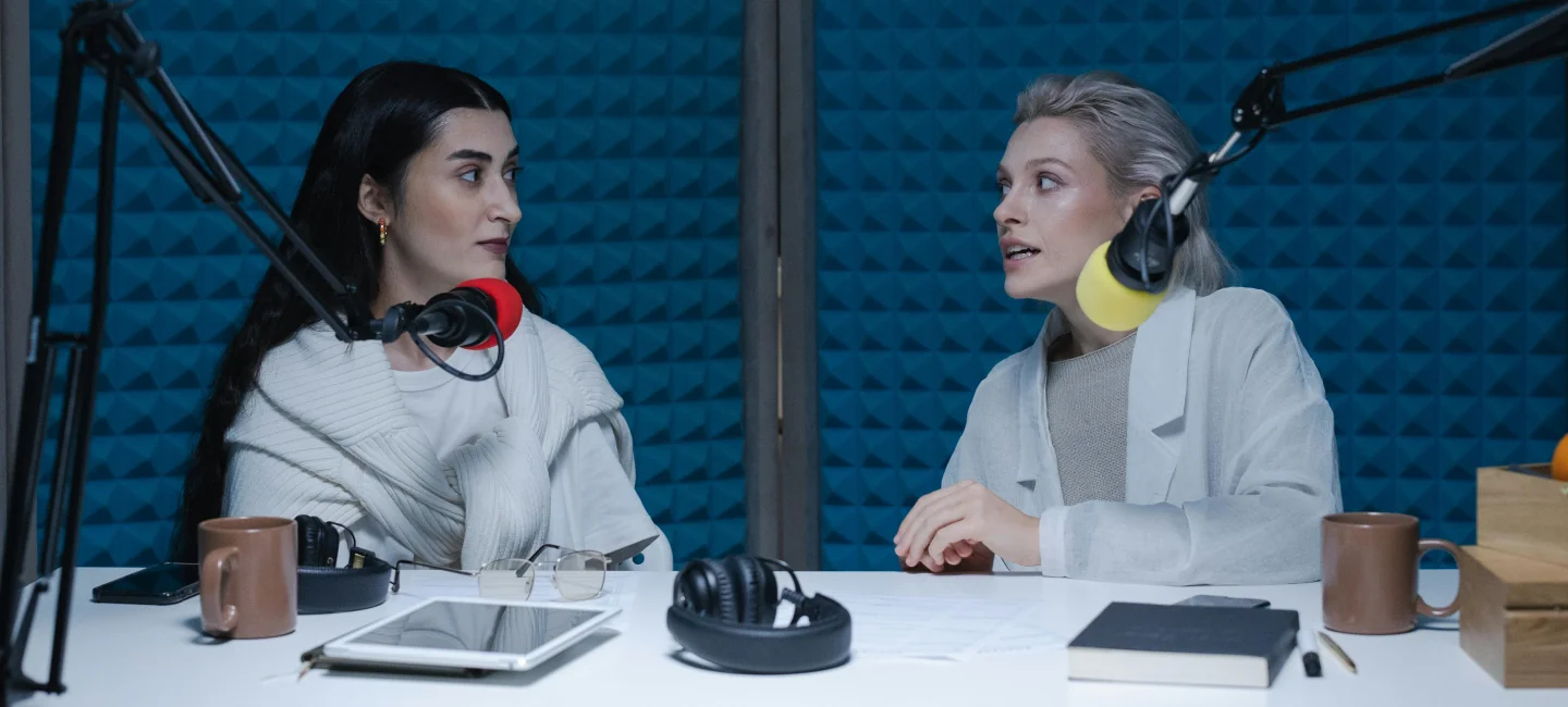 Image of two women recording a podcast 